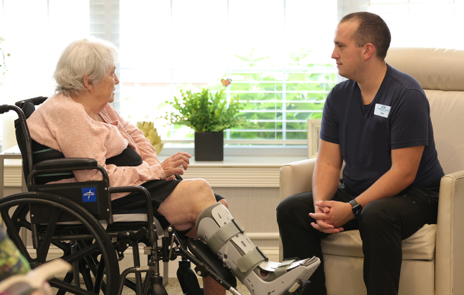 Staff member listening to a resident in a wheelchair